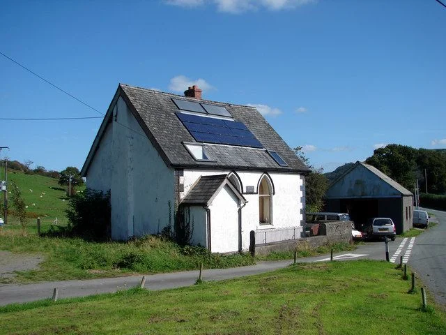 Solar panels like these on a 19th century cottage in Llanwrin, Powys, are likely to be discouraged in future, as the coalition government has decided to wind down funding for such projects. Photo: OLU (commons.wikimedia.org). Solar panels like these on a 19th century cottage in Llanwrin, Powys, are likely to be discouraged in future, as the coalition government has decided to wind down funding for such projects. Photo: OLU (commons.wikimedia.org).
